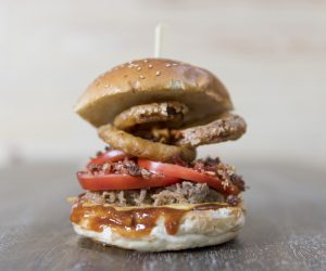 Con aros de cebolla tomate bacon queso americano y salsa barbacoa