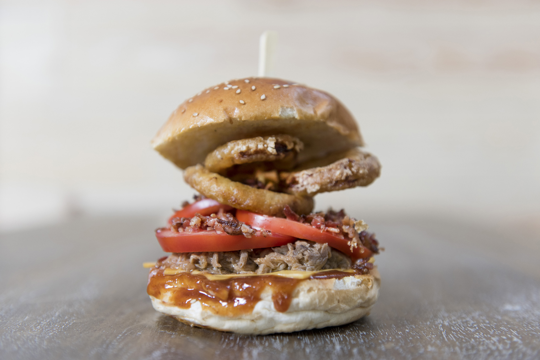 Con aros de cebolla tomate bacon queso americano y salsa barbacoa
